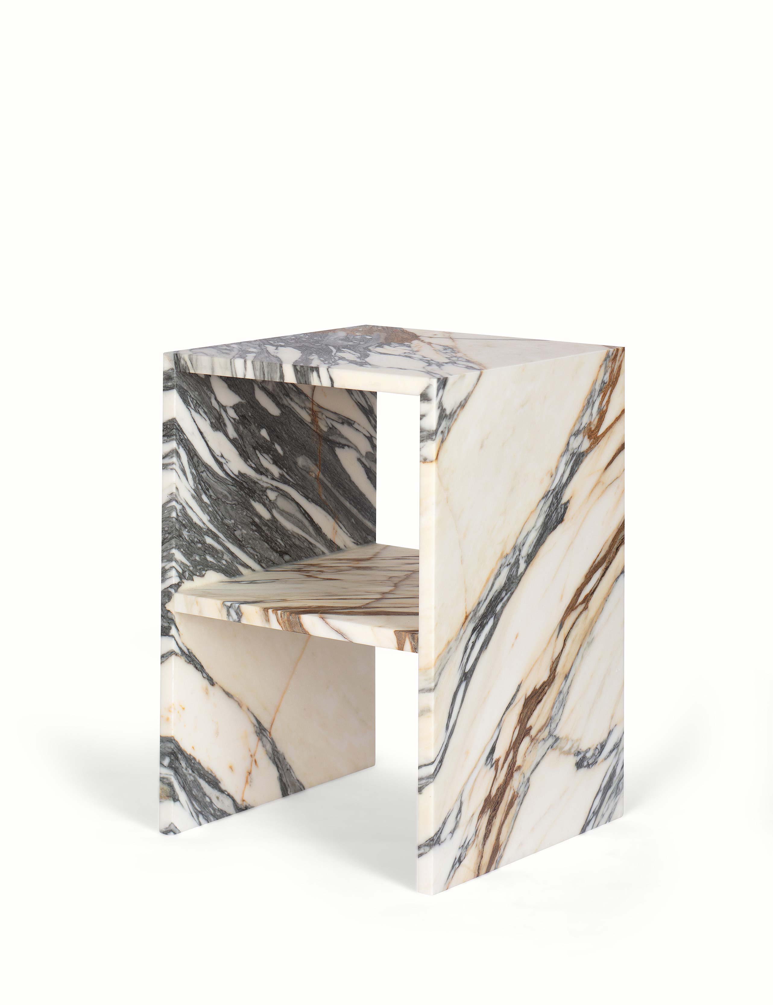 Vooraanzicht van een elegant nachtkastje of bijzettafel gemaakt van natuursteen. Tijdloos in kwaliteit en stijl, in een hoekig design met opbergmogelijkheid. Uitgevoerd in een unieke en exclusieve marmer: Golden Veil, met levendige gouden en grijze aderen.