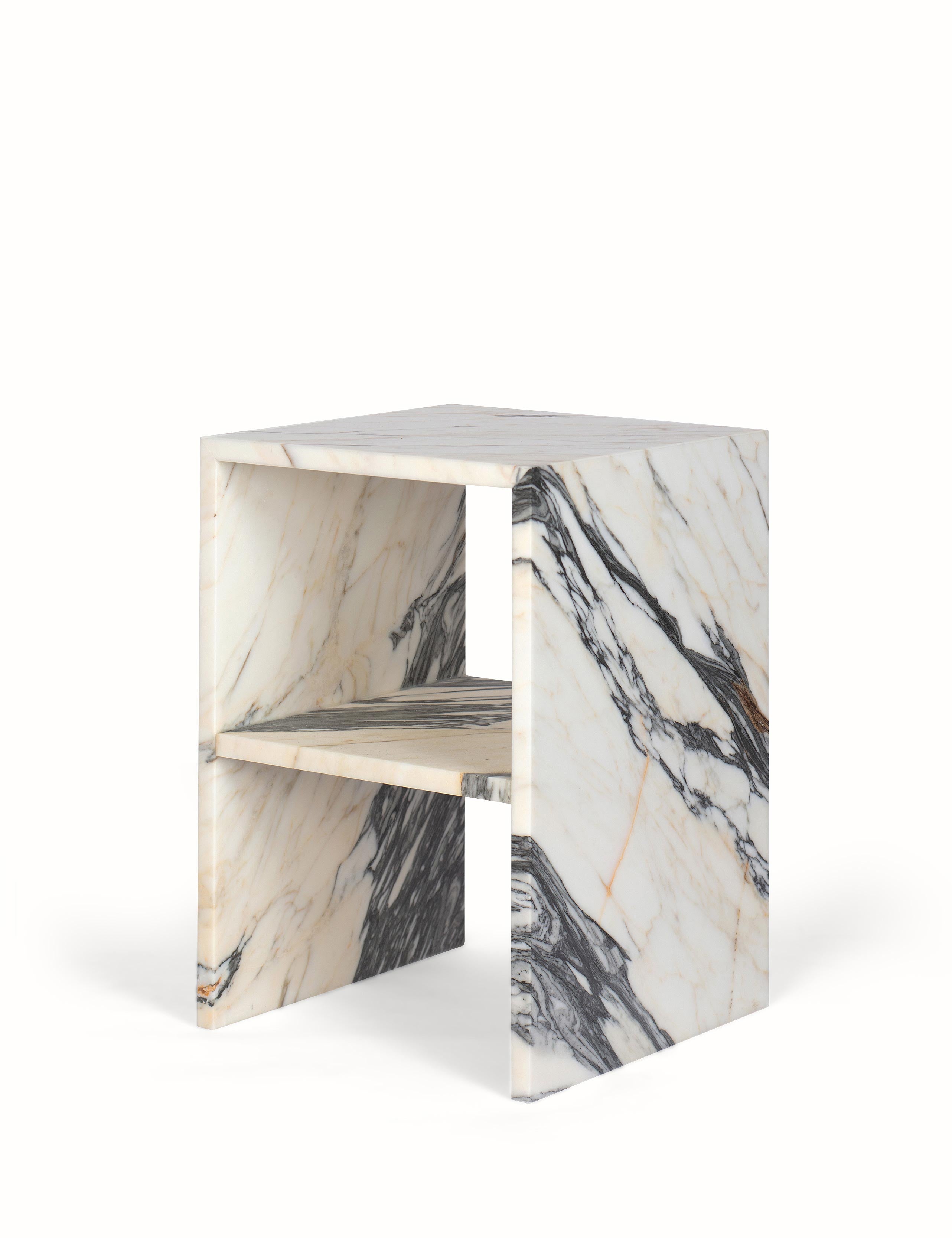 Vooraanzicht van een elegant nachtkastje of bijzettafel gemaakt van natuursteen. Tijdloos in kwaliteit en stijl, in een hoekig design met opbergmogelijkheid. Uitgevoerd in een unieke en exclusieve marmer: Golden Veil, met levendige gouden en grijze aderen.