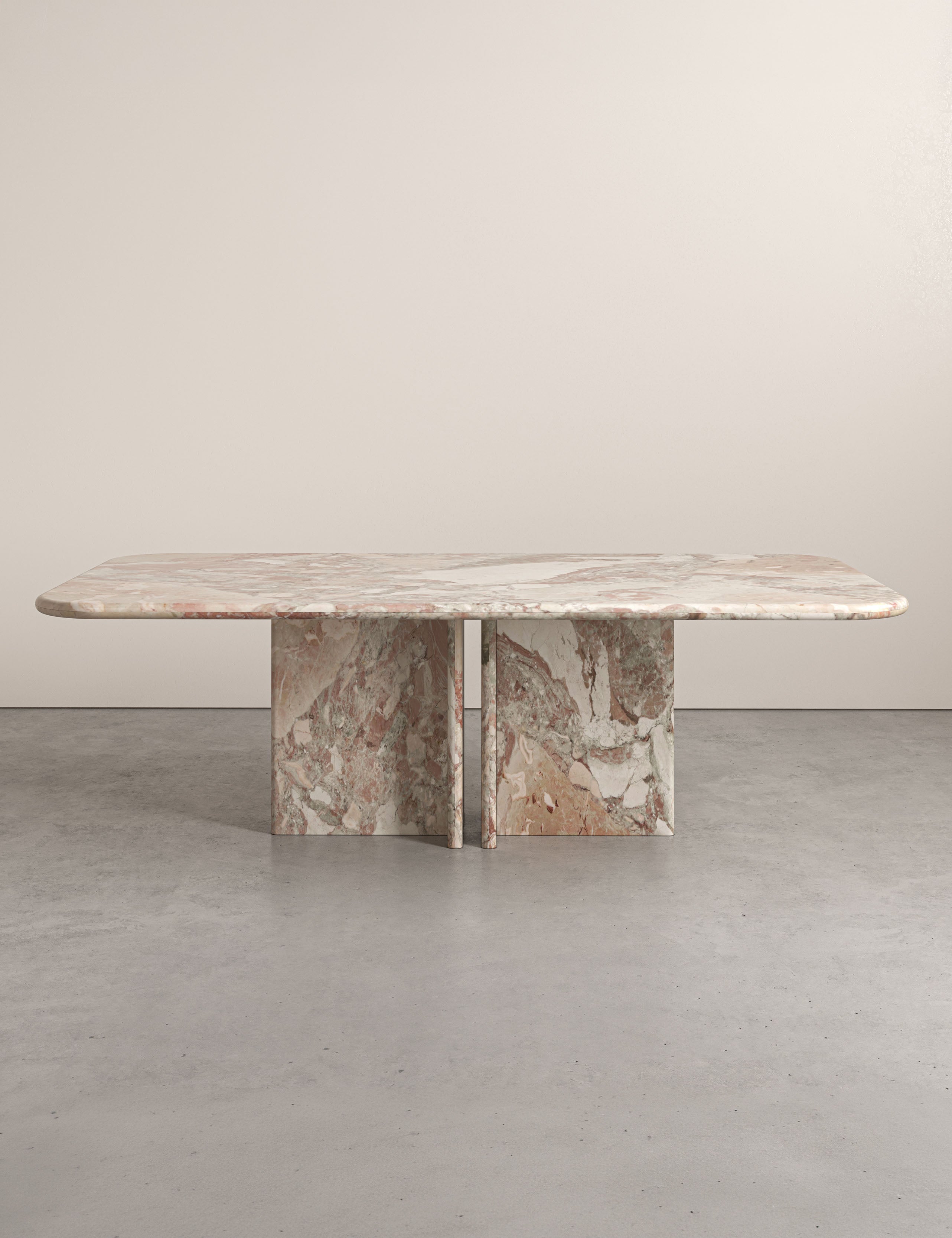 Lumo dining table in Ceppo botticelli marble with rounded rectangular top and four sculptural pedestal legs.