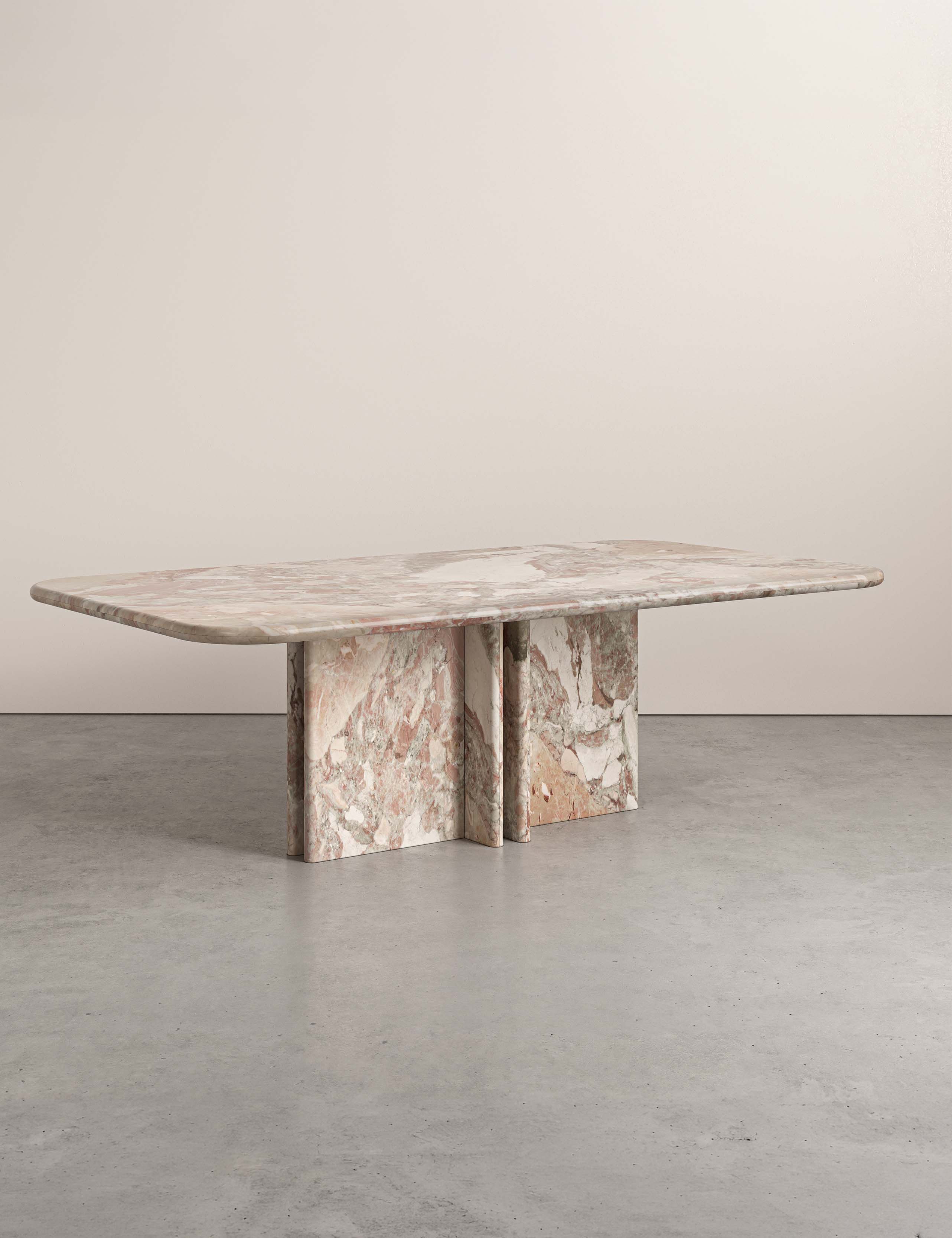 Side view of Lumo ceppo botticelli marble dining table with four pedestal legs and rounded rectangular top.