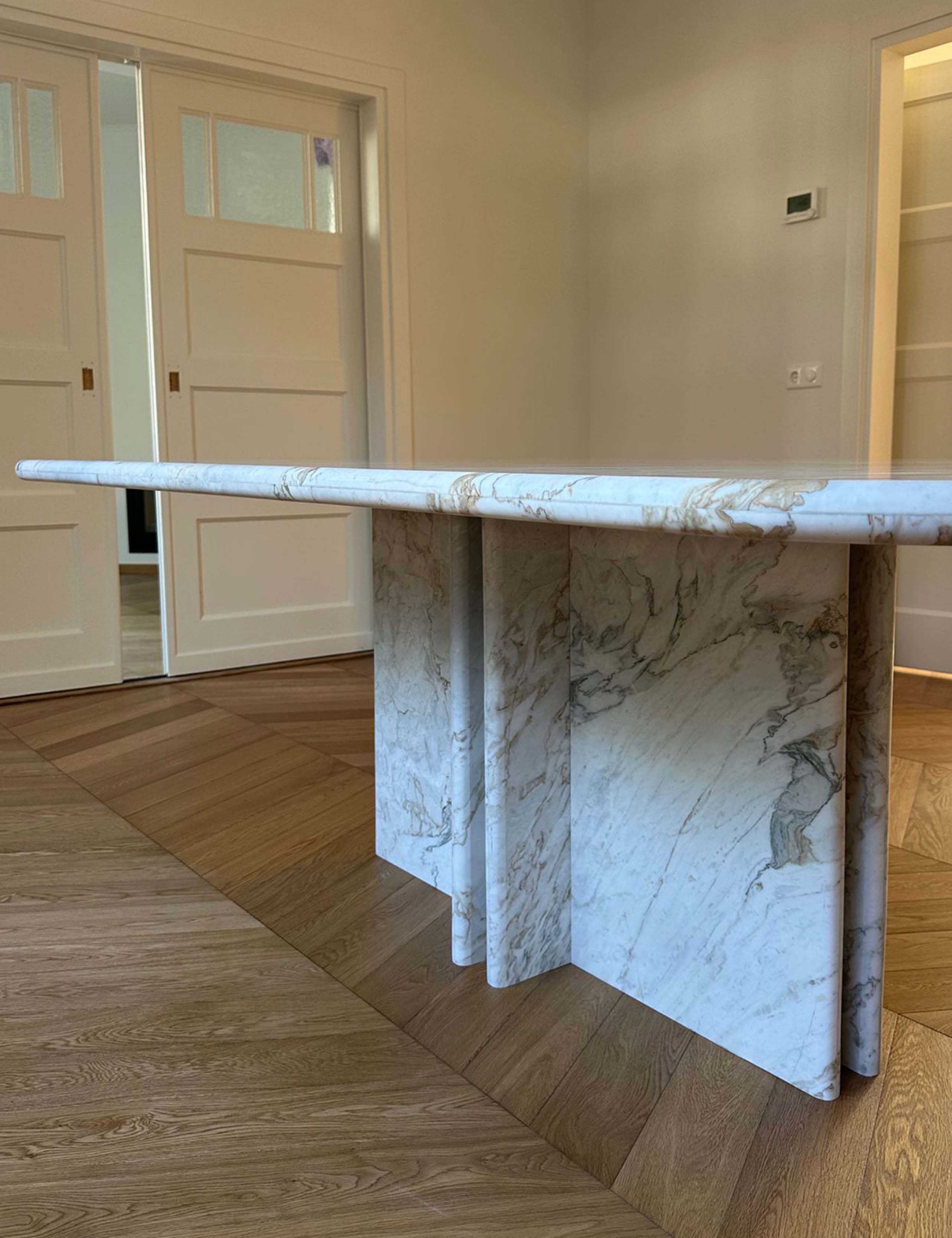 Detail of marble dining table base with sculptural pedestal legs.