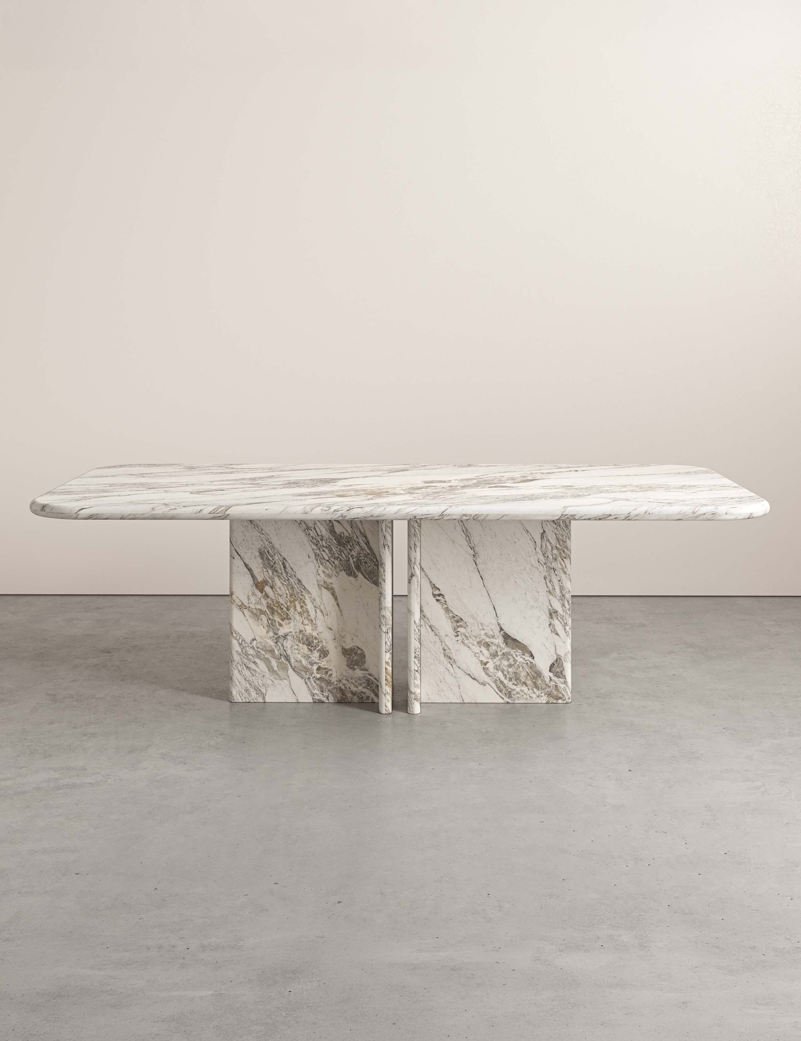 Lumo dining table in Ceppo di Vagli marble with rounded rectangular top and four sculptural pedestal legs.