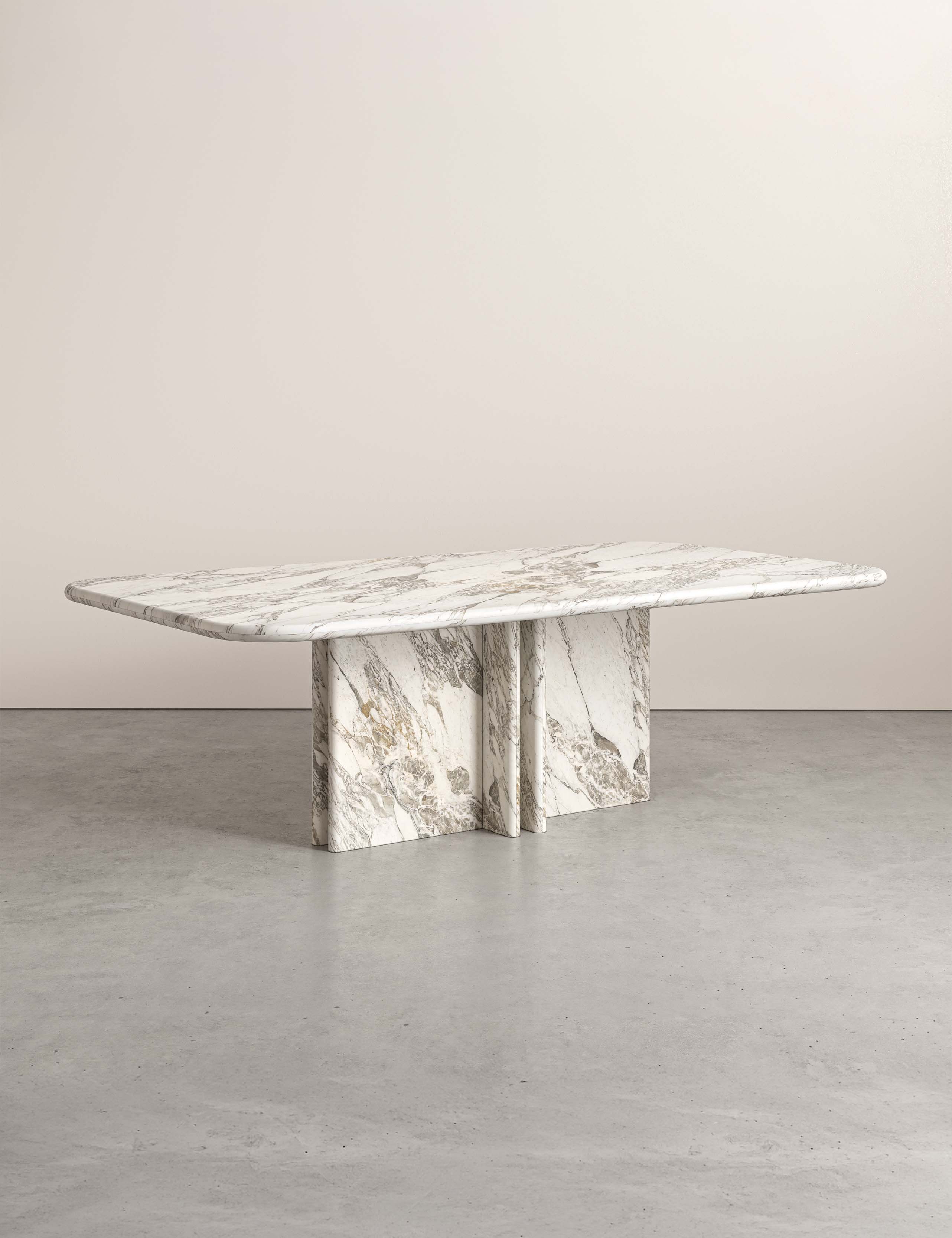 Side view of Lumo marble dining table with four pedestal legs and rounded rectangular top.