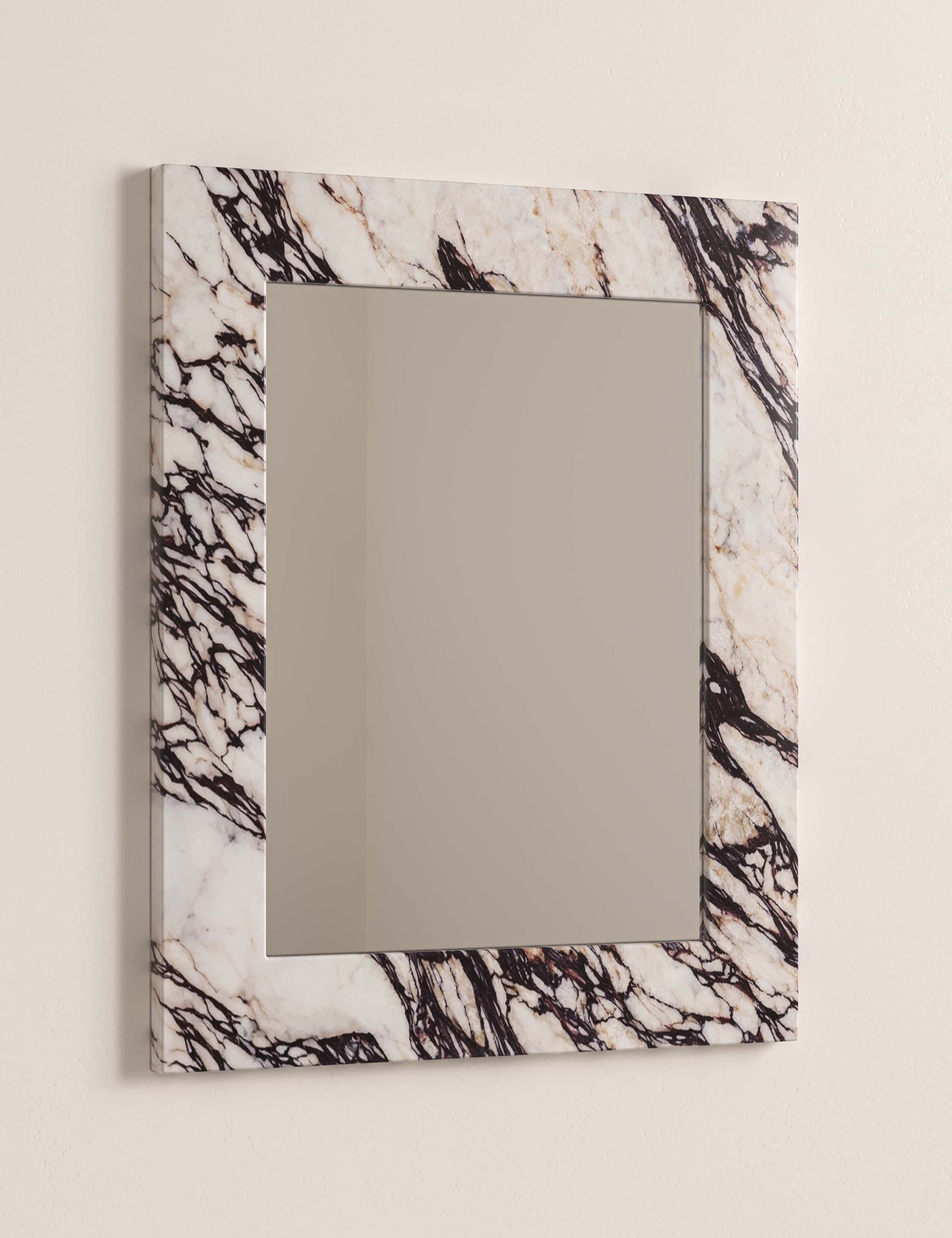 Detail of Calacatta Viola marble wall mirror Opal showing dramatic burgundy veining in natural stone.